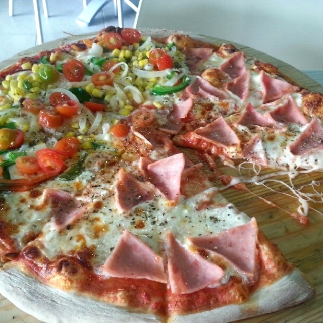 Pizza mitad jamon y mitad vegetariana sin aceitunas.