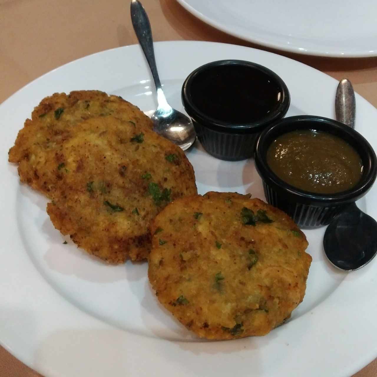 Fish Tikki (arepitas de pescado con papa, acompañados de salsa BBQ con especias y chimichurri picoso).