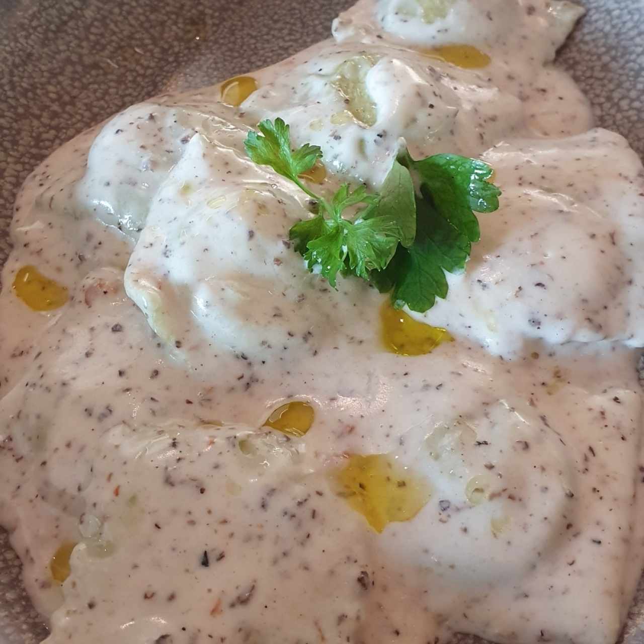 Raviolis rellenos de espinaca con queso crema y salsa de trufas