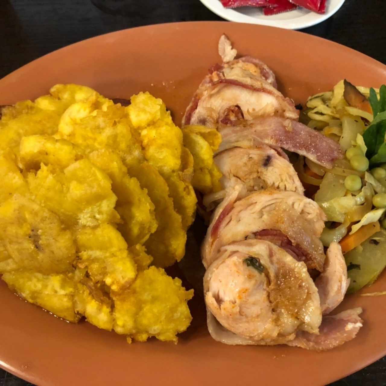 Pechuga de Pollo con tocino y sofrito dulce, acompañado de patacones.