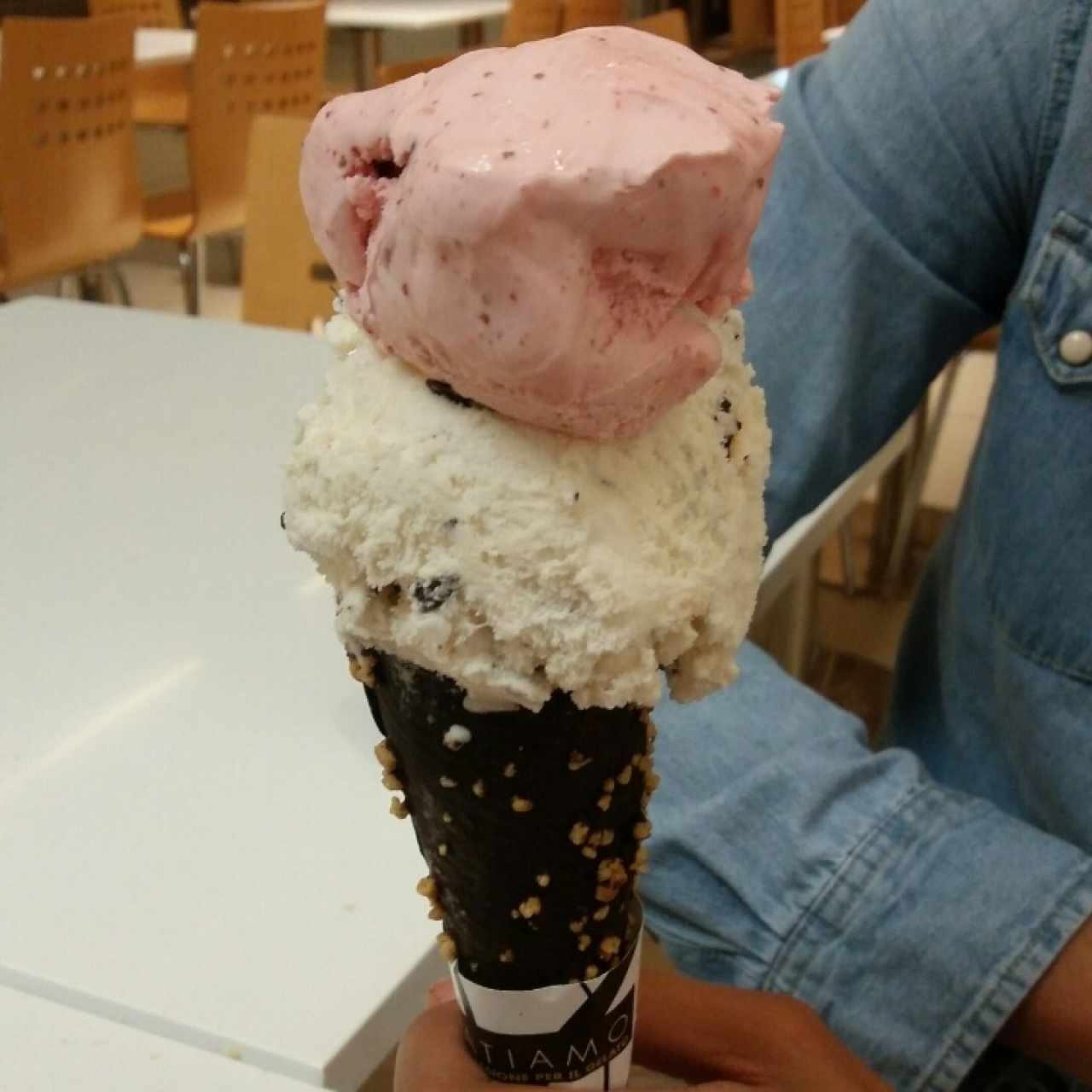 Helado de fresa con crema de chocolate en cono bañado de chocolate con almendras 