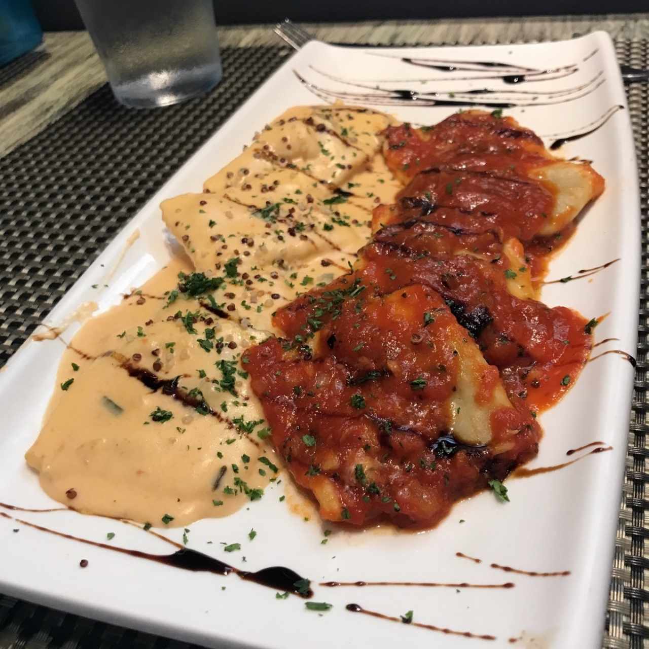 Duo de Ravioli de Salmon Ahumado y Queso Ricotta, a la Crema de Cebollina Junto a Raviolis de Berenjena a la Pizzaiola.