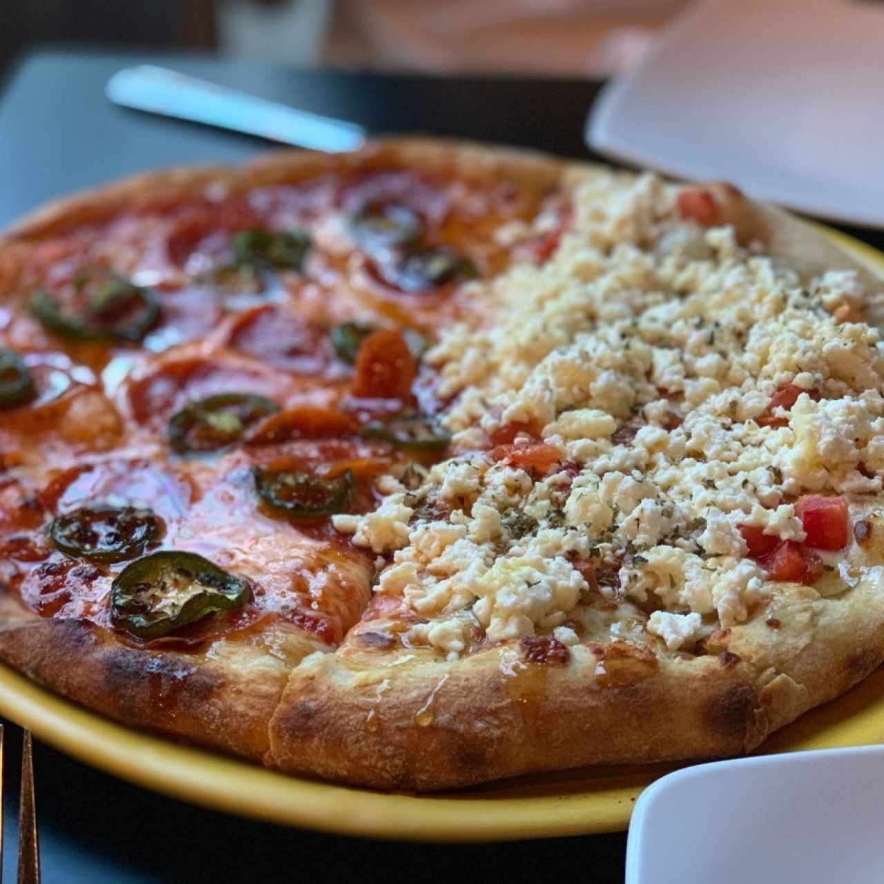 Pizza mitad peperoni , jalapeño y miel , aueso feta y tomates 