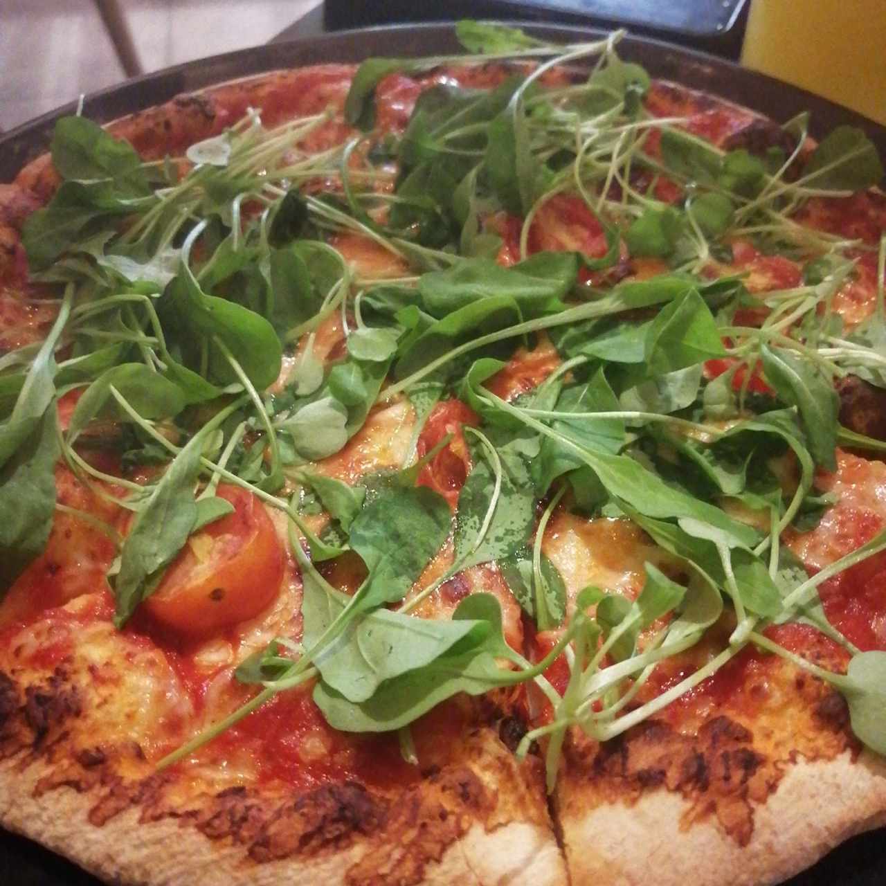 Pizza de arúgula y tomates cherry