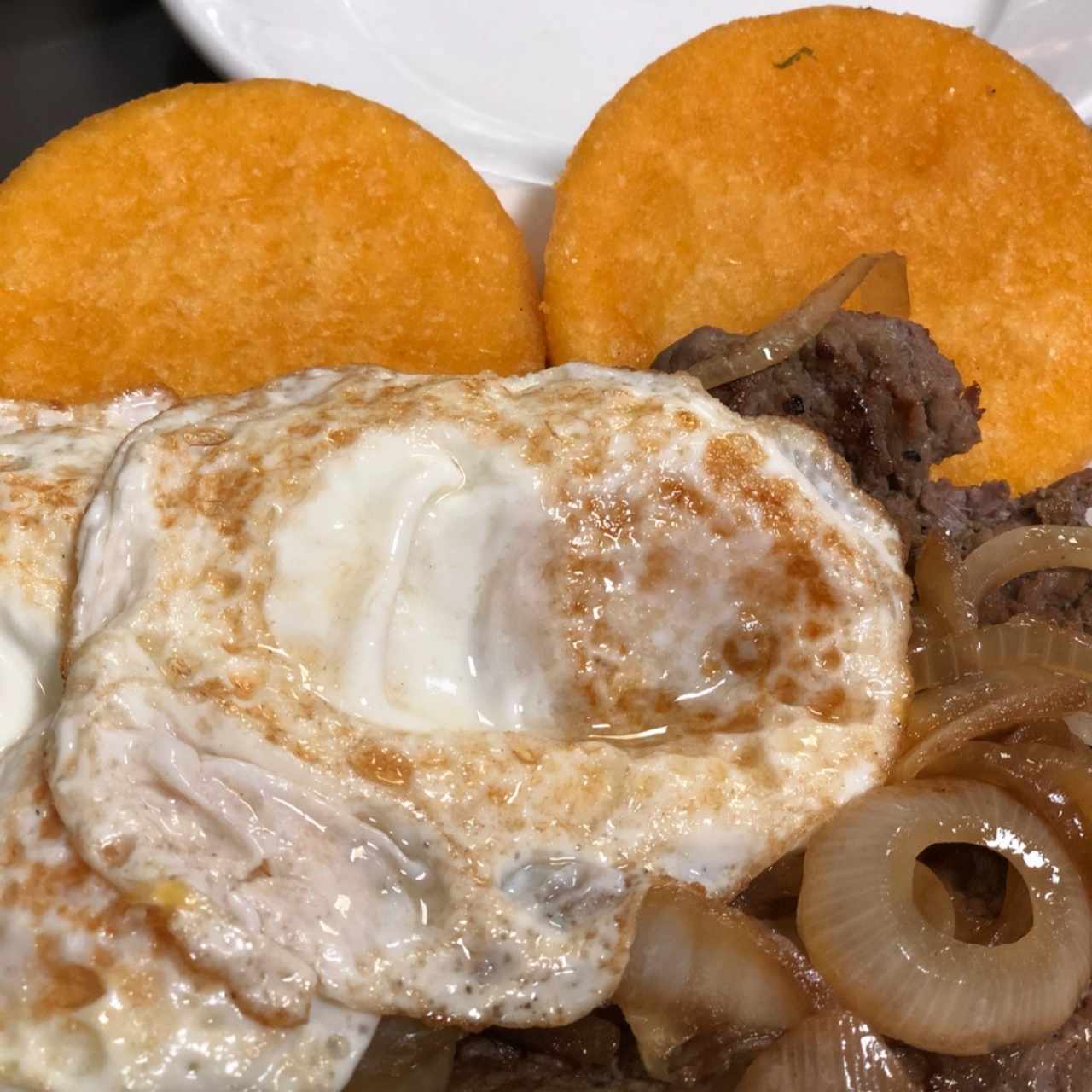 bistec de carne encebollado a caballo con tortillas