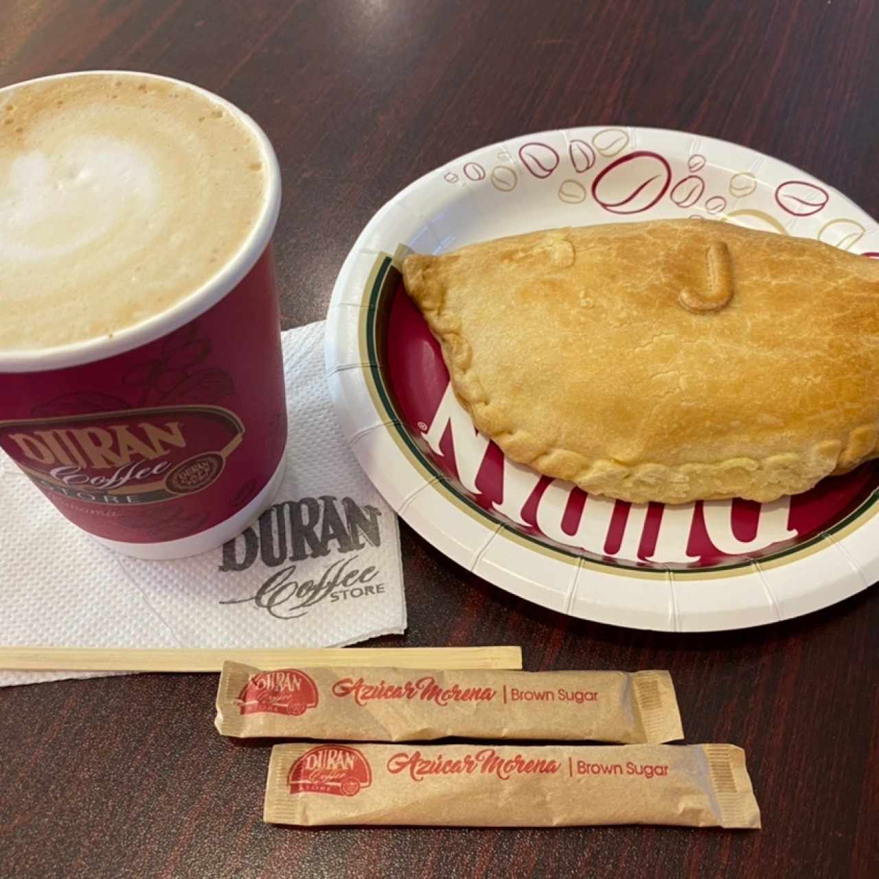 Capuchino chico y empanada de jamon y queso