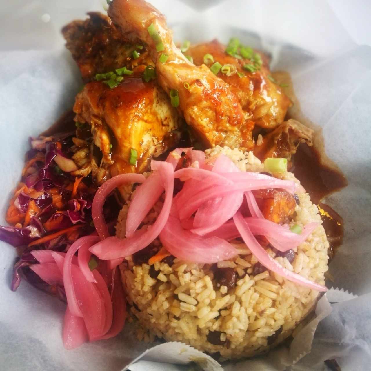 Jerk Chicken con Arroz y guandu las cebollas es un extra de otro plato