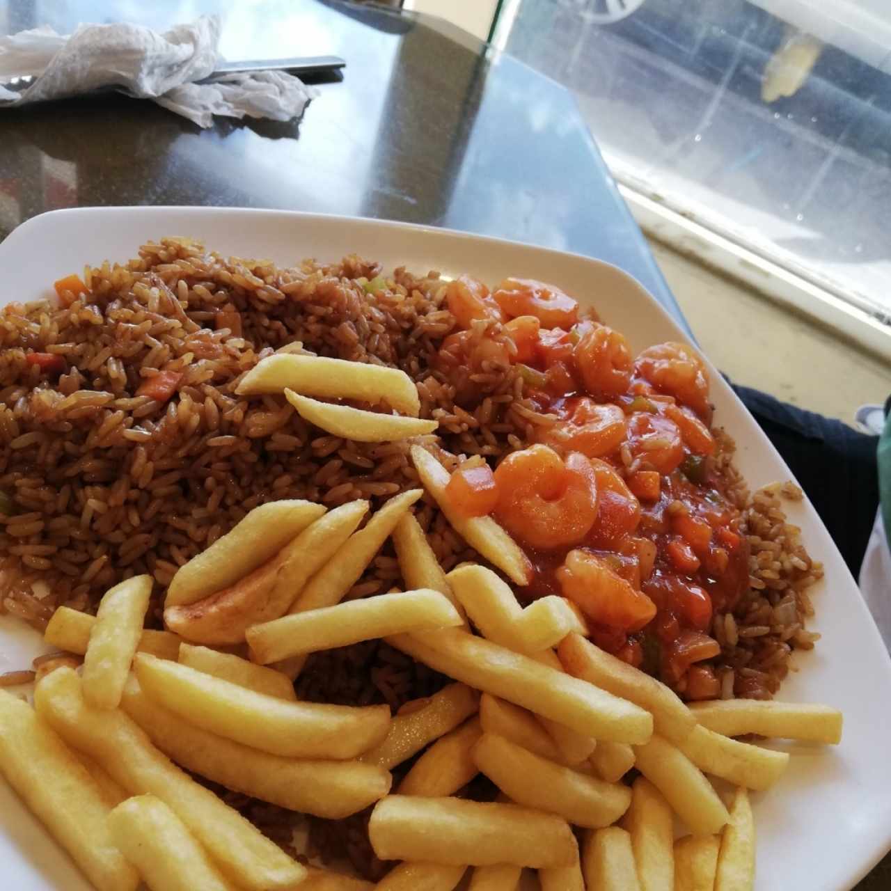 Arroz frito con camarones guizados y papas fritas