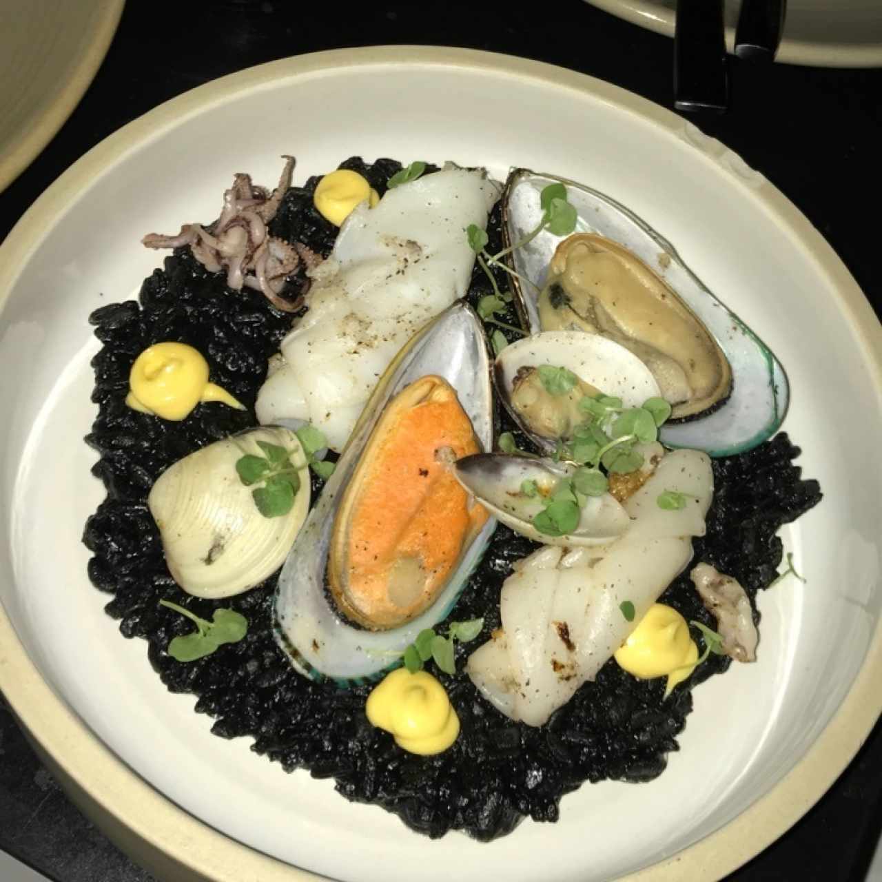 Rissoto nero con calamares, almejas y mejillones flambeados en brandy