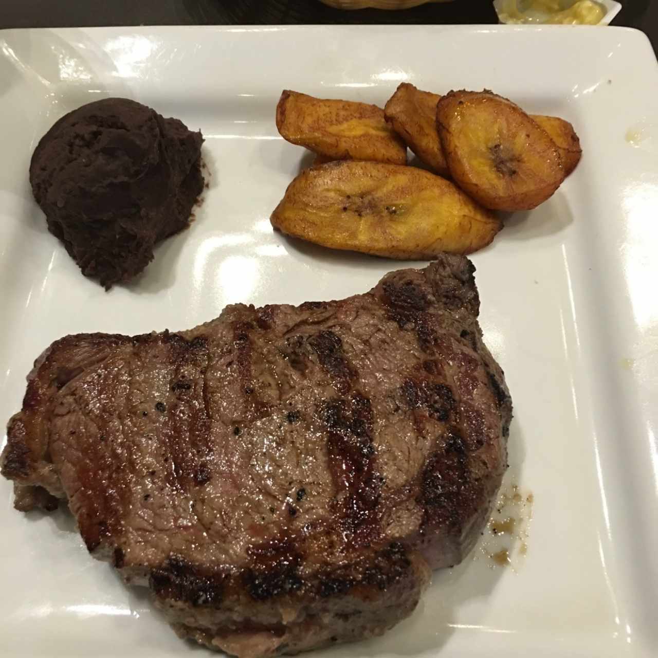 bife de chorizo con pure de frijoles y platano maduro