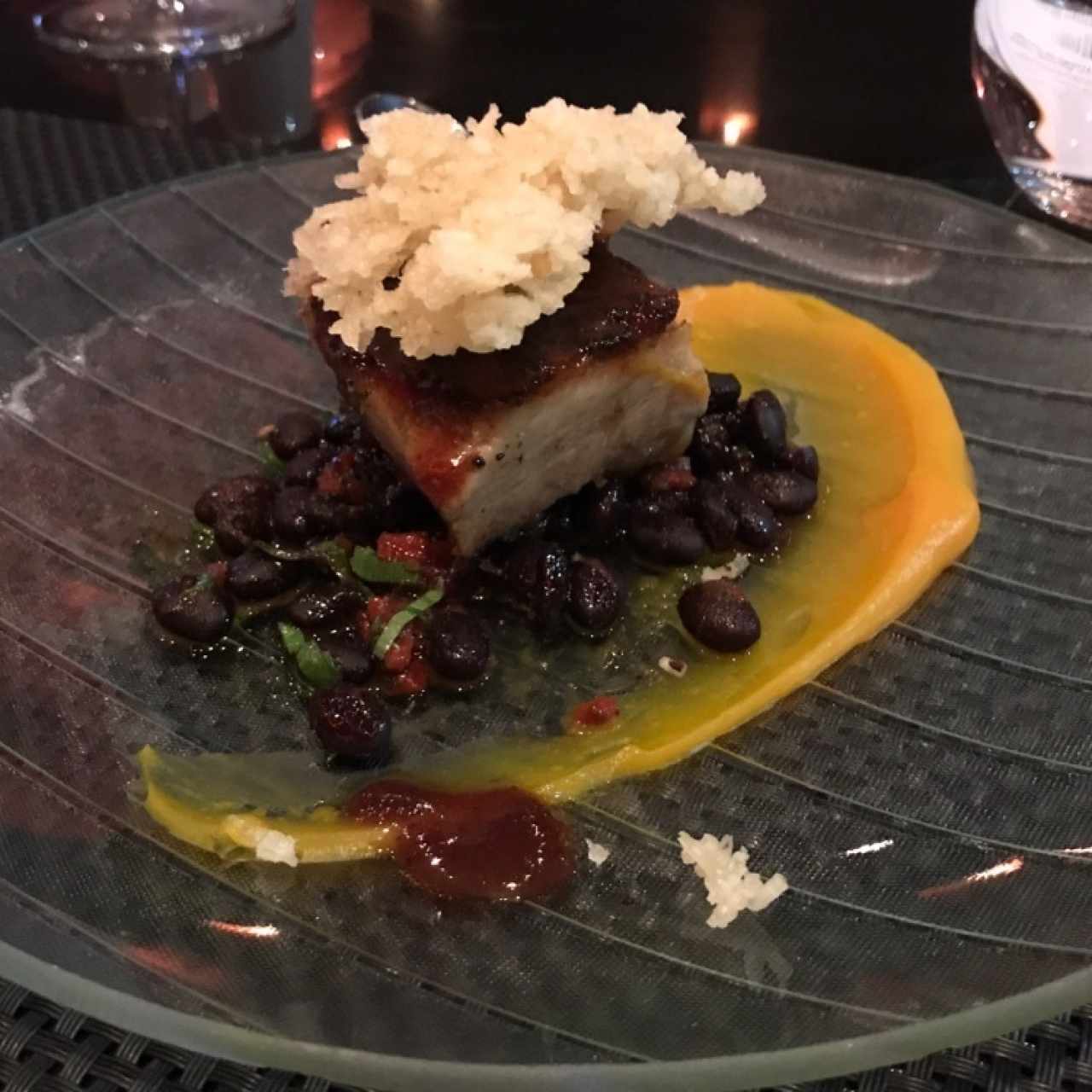 Porkbelly con arroz inflado, frijoles marinados y glaseado de raspadura con saril