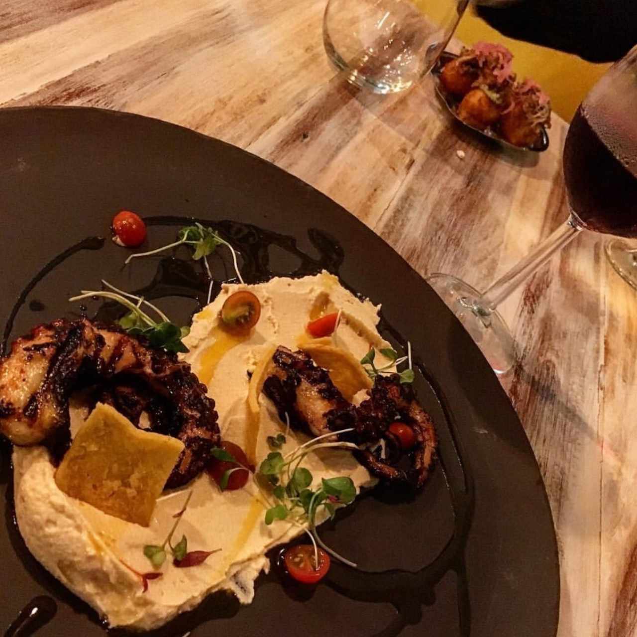 pulpo al grill con aceite de chorizo tableños y humus preparado en caso