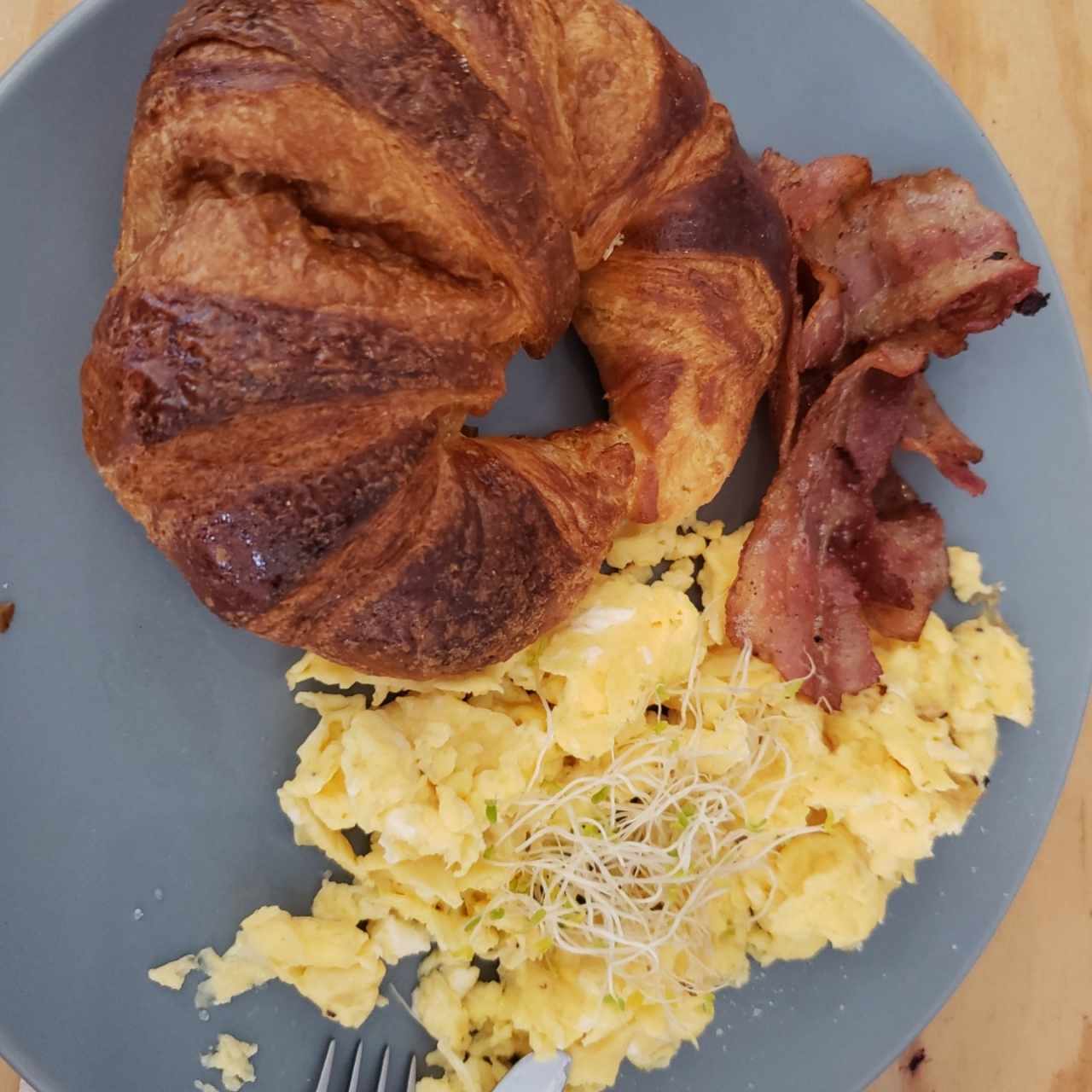 Huevos revueltos con bacon y croissant