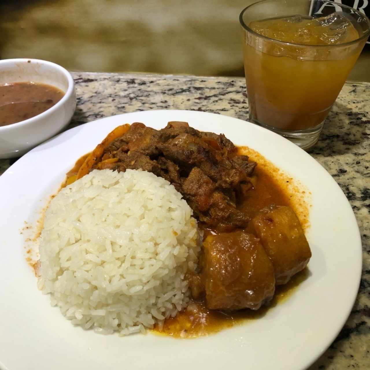 Bistec picado con platano ententación, porotos, arroz blanco y chicha de naranja con miel