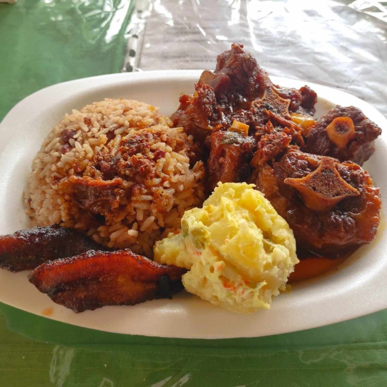 Rabo encendido, arroz de coco, ensalada de papas y plátano frito maduro. 