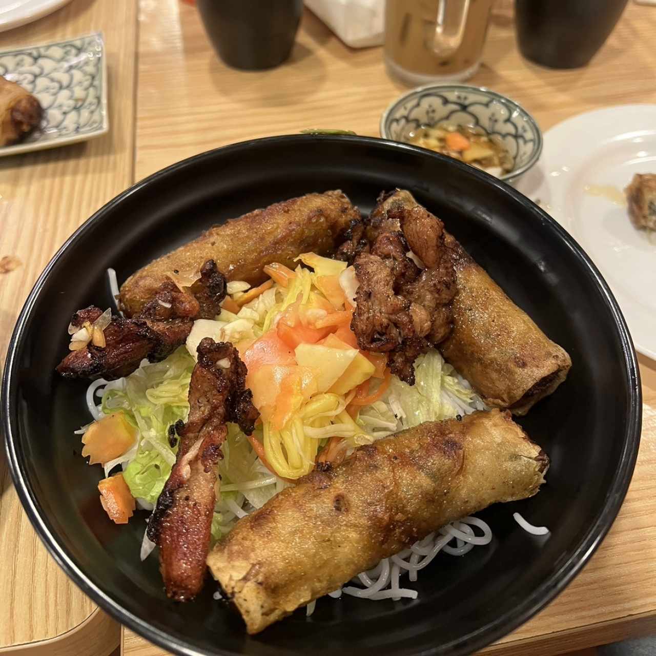 Fideo de arroz con puerco y rollitos