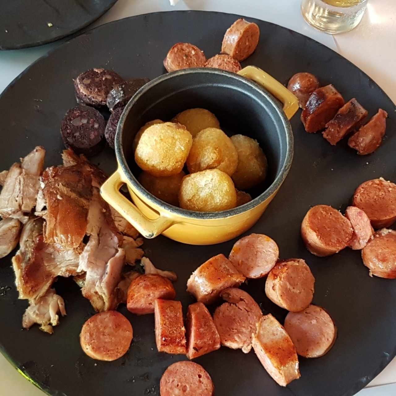 Entrada de chorizos, morcilla y cerdo con buñuelos de yuca.