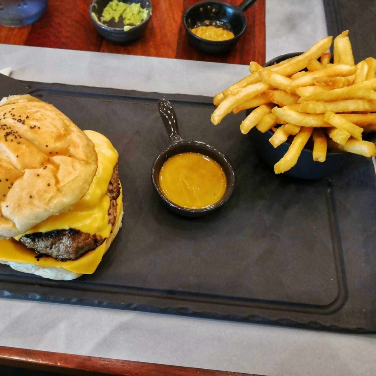 Hamburguesa acompaña de papas y salsa mostaza-miel