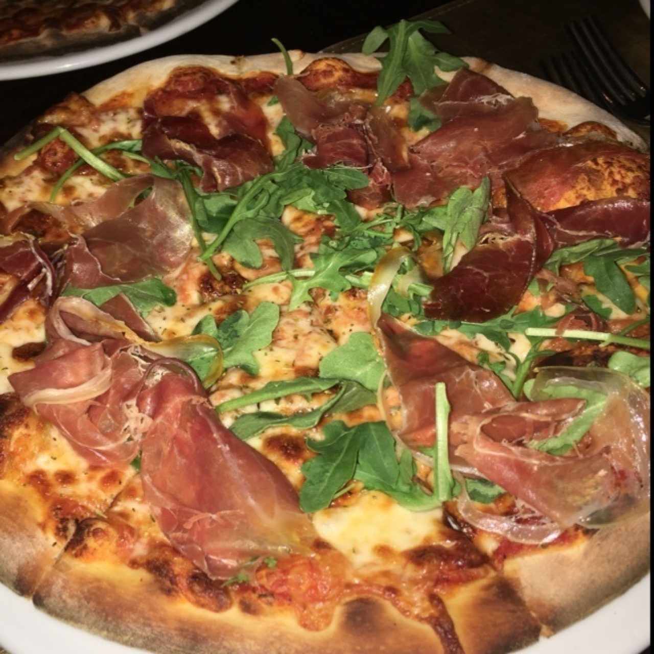 Pizza de prosciutto con albahaca  