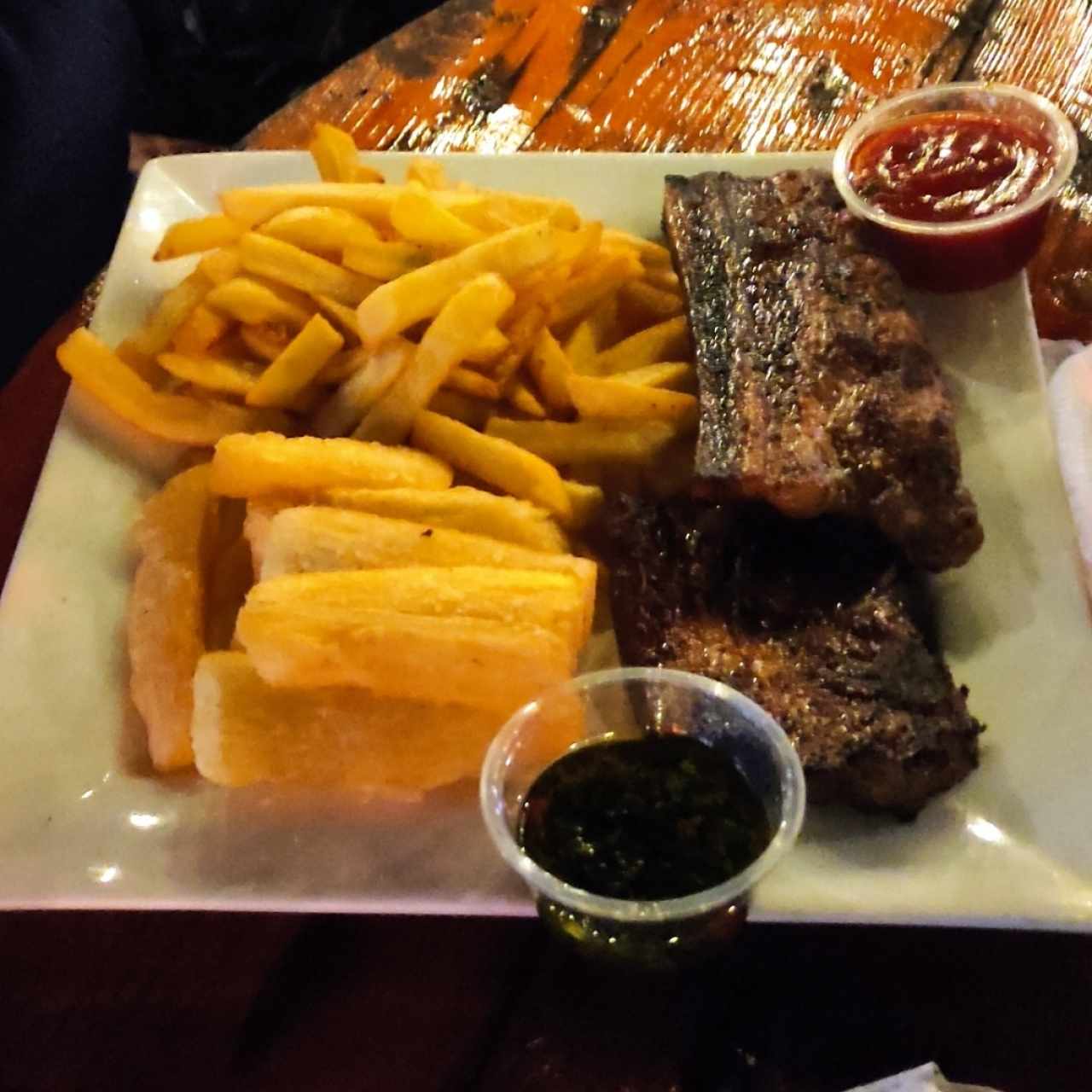 Costillitas de cerdo con yuca frita y papitas