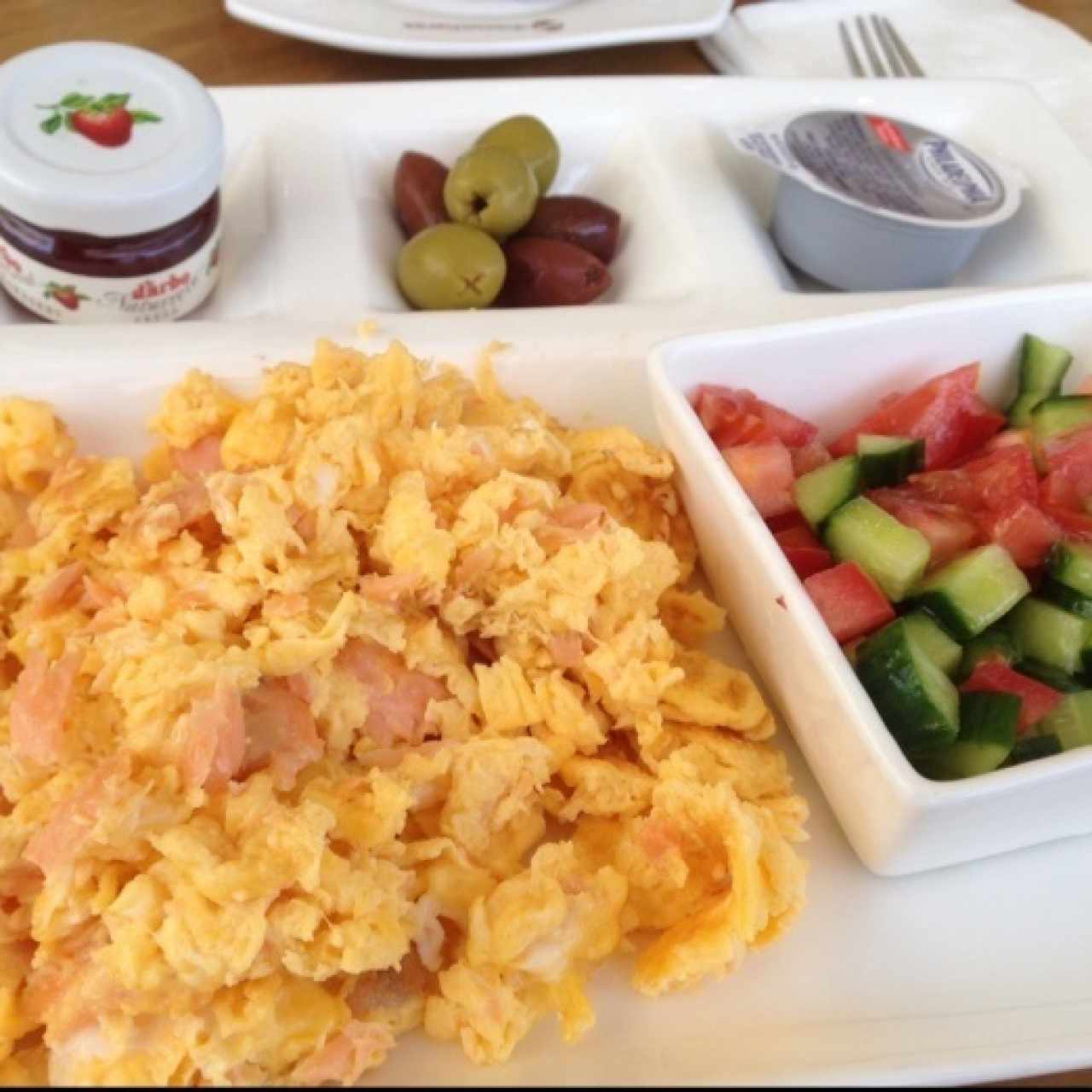 huevos revueltos con salmón ahumado, aceitunas, baguette y opcion de ensaladas