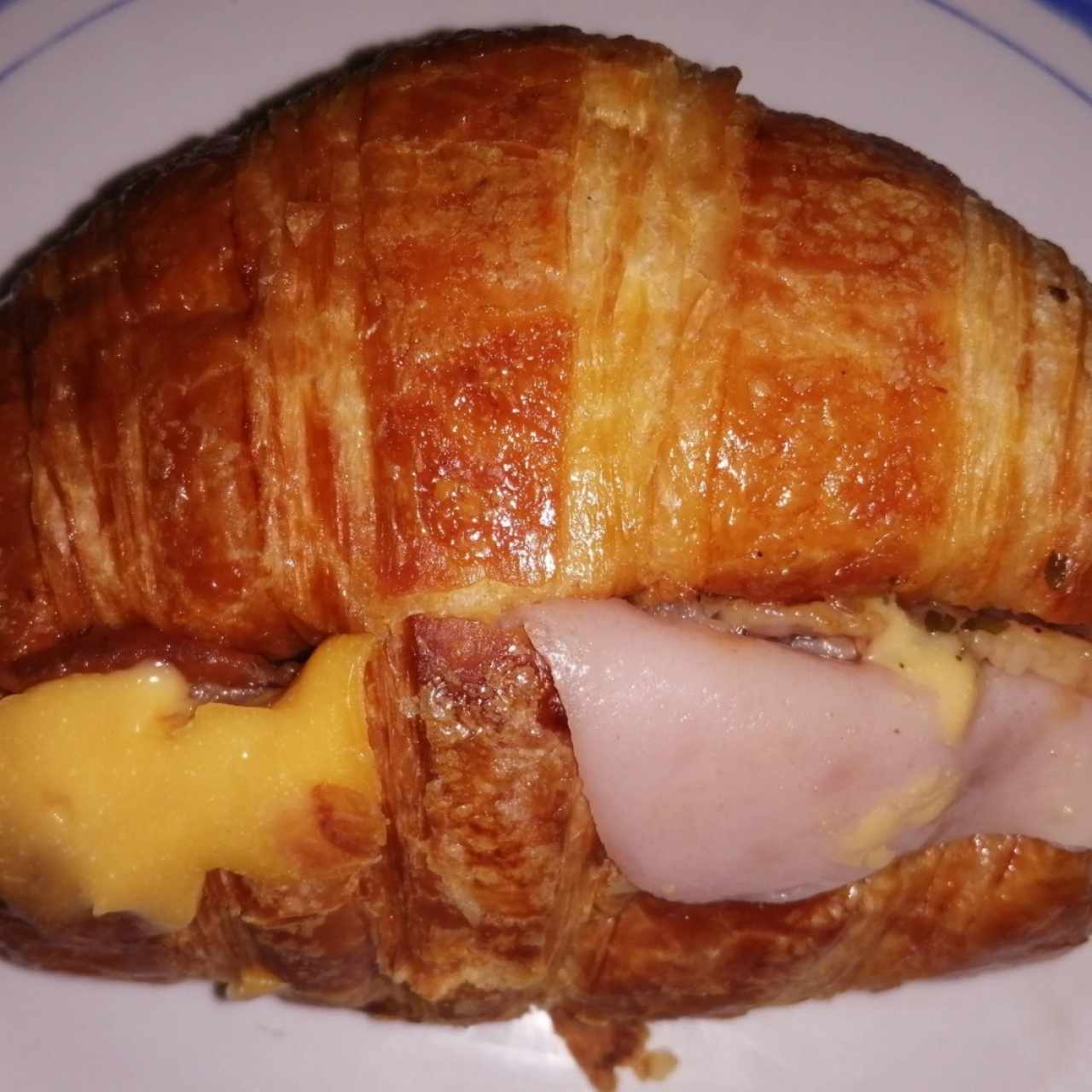 Sandwich de croissant de jamón, queso y bacon