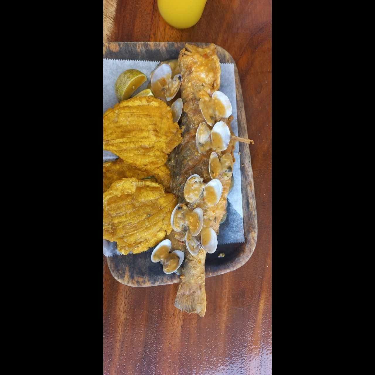 Pescado entero frito en salsa de almejas con patacones