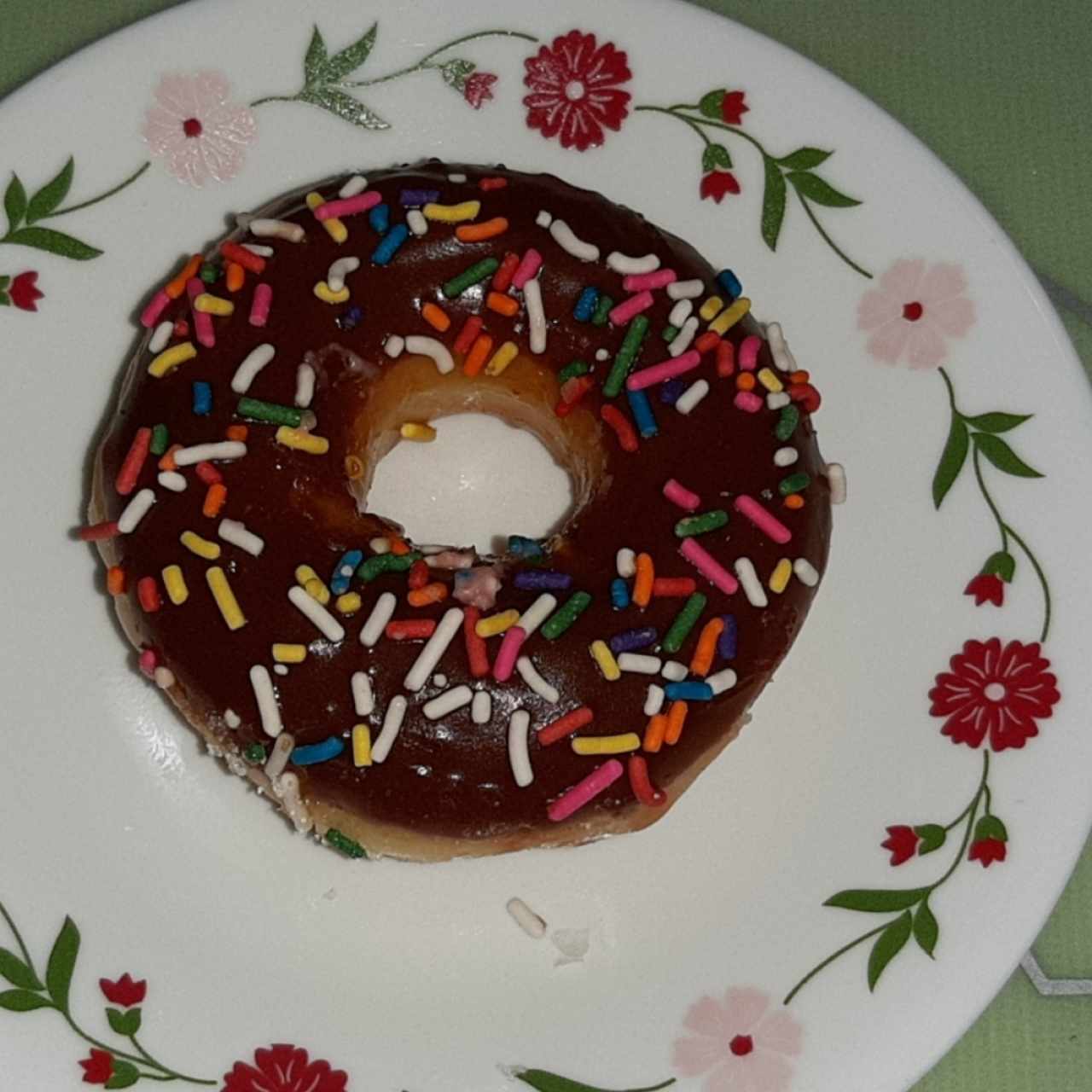 donut glaceado de chocolate y chispas de colores