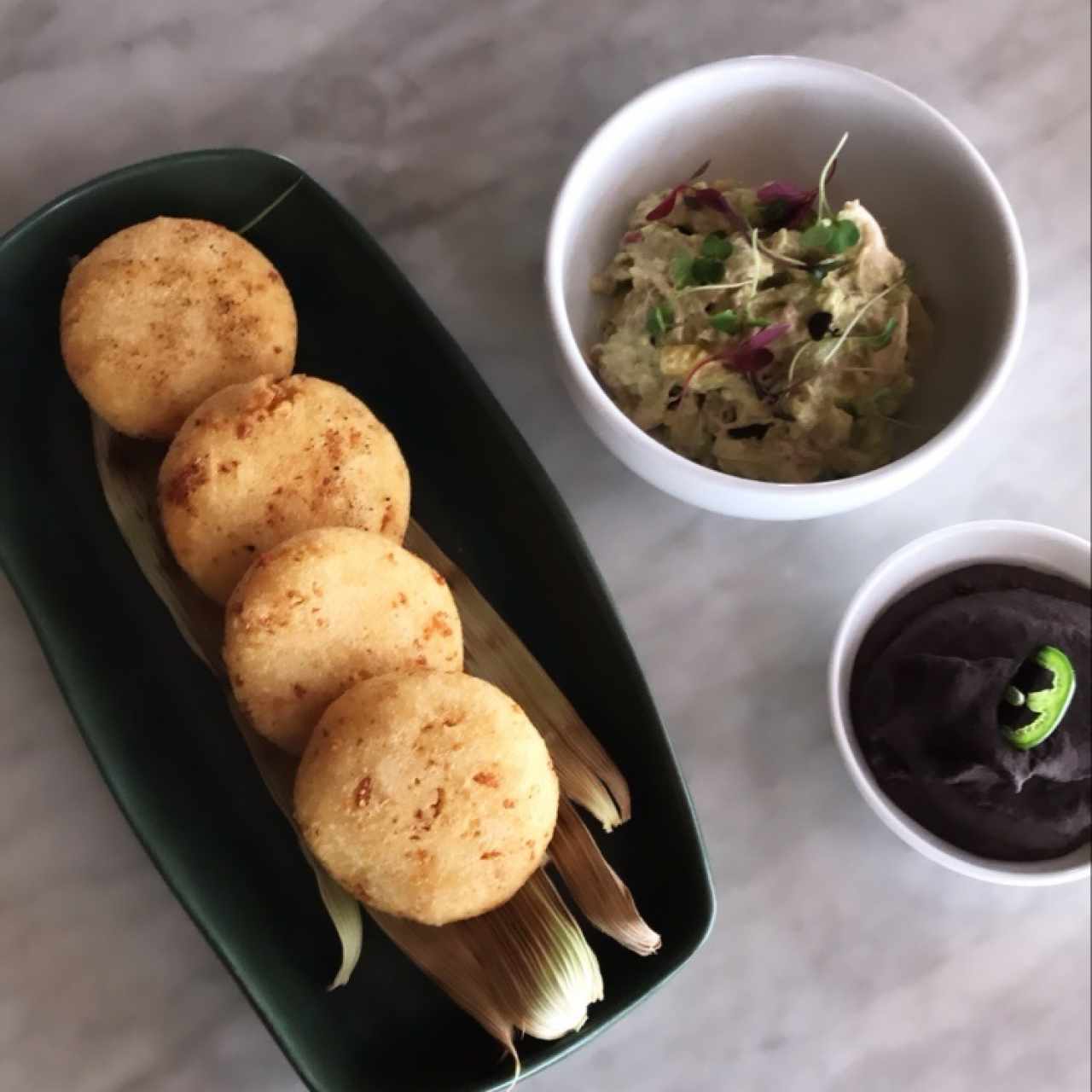 arepitas de chicharon y queso nacional con su reina y refrito de frijoles negros 