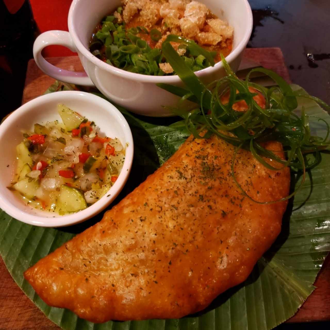 empanada de cerdo y provolone con salsa de guachito y vegetales encurtidos 