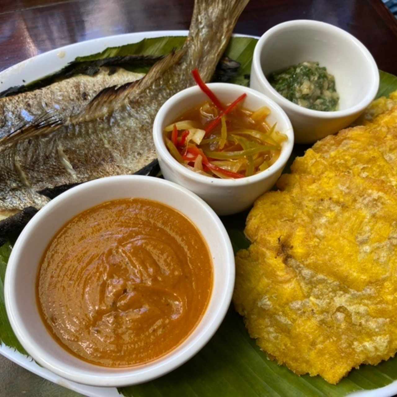 corvina al horno en hoja de bijao, tamal de olla, patacones y salsas