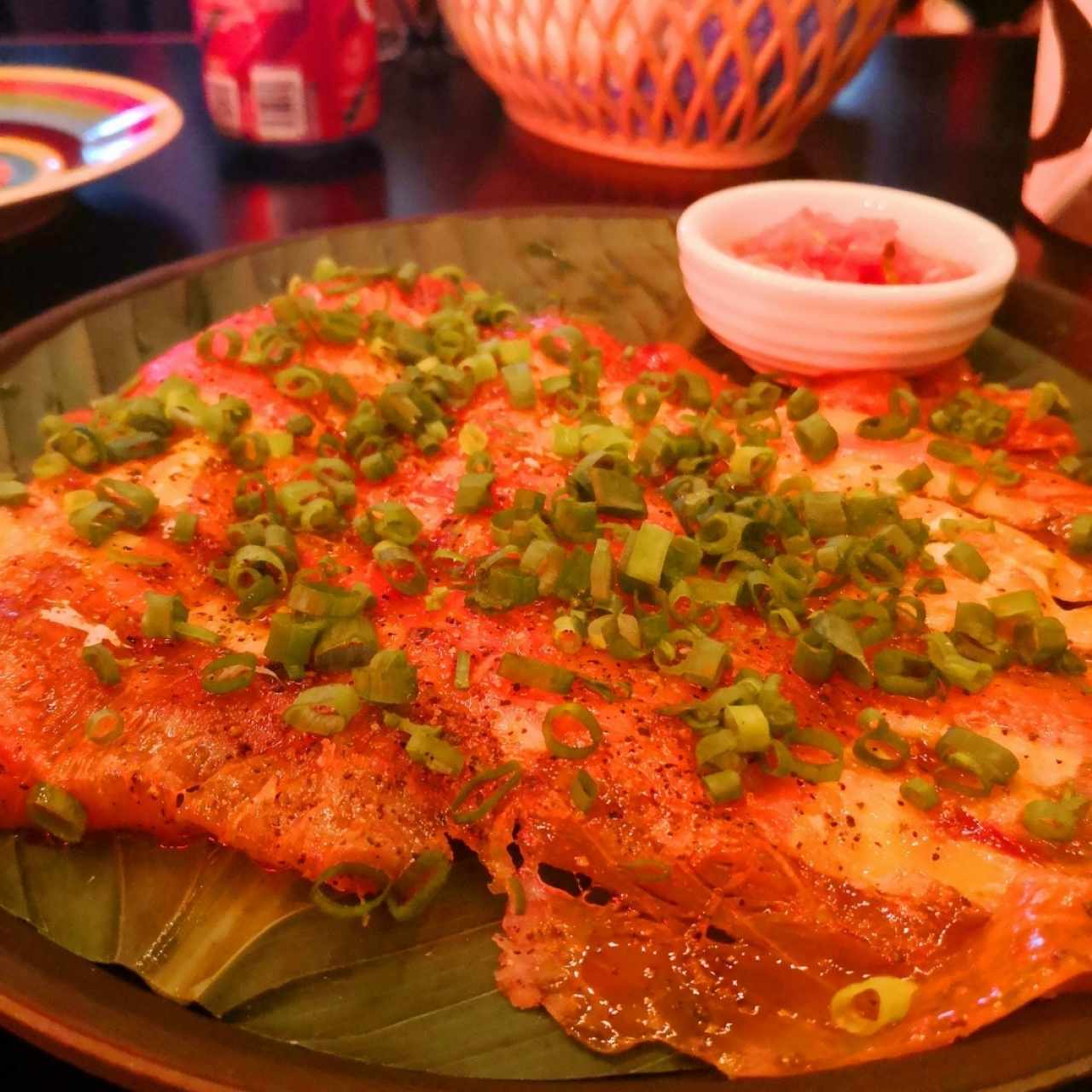 Carpaccio de salmón con yuca tostada y encurtido de cebolla