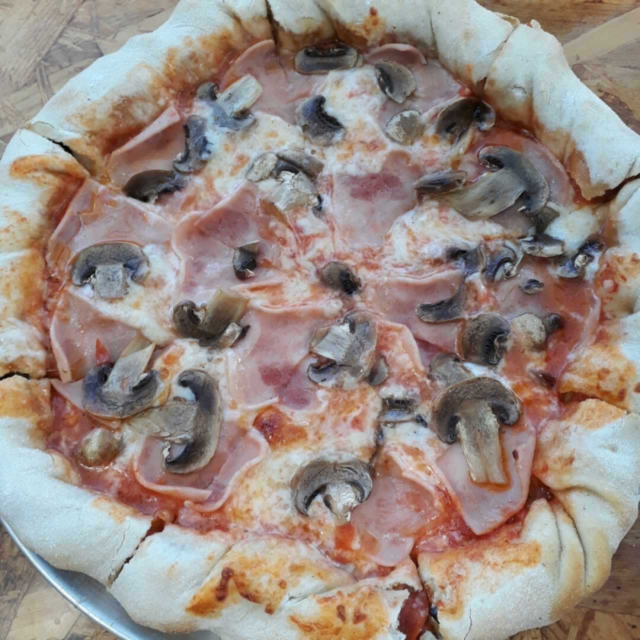 Pizza de jamón y champiñones. con borde de peperoni, aceitunas y queso