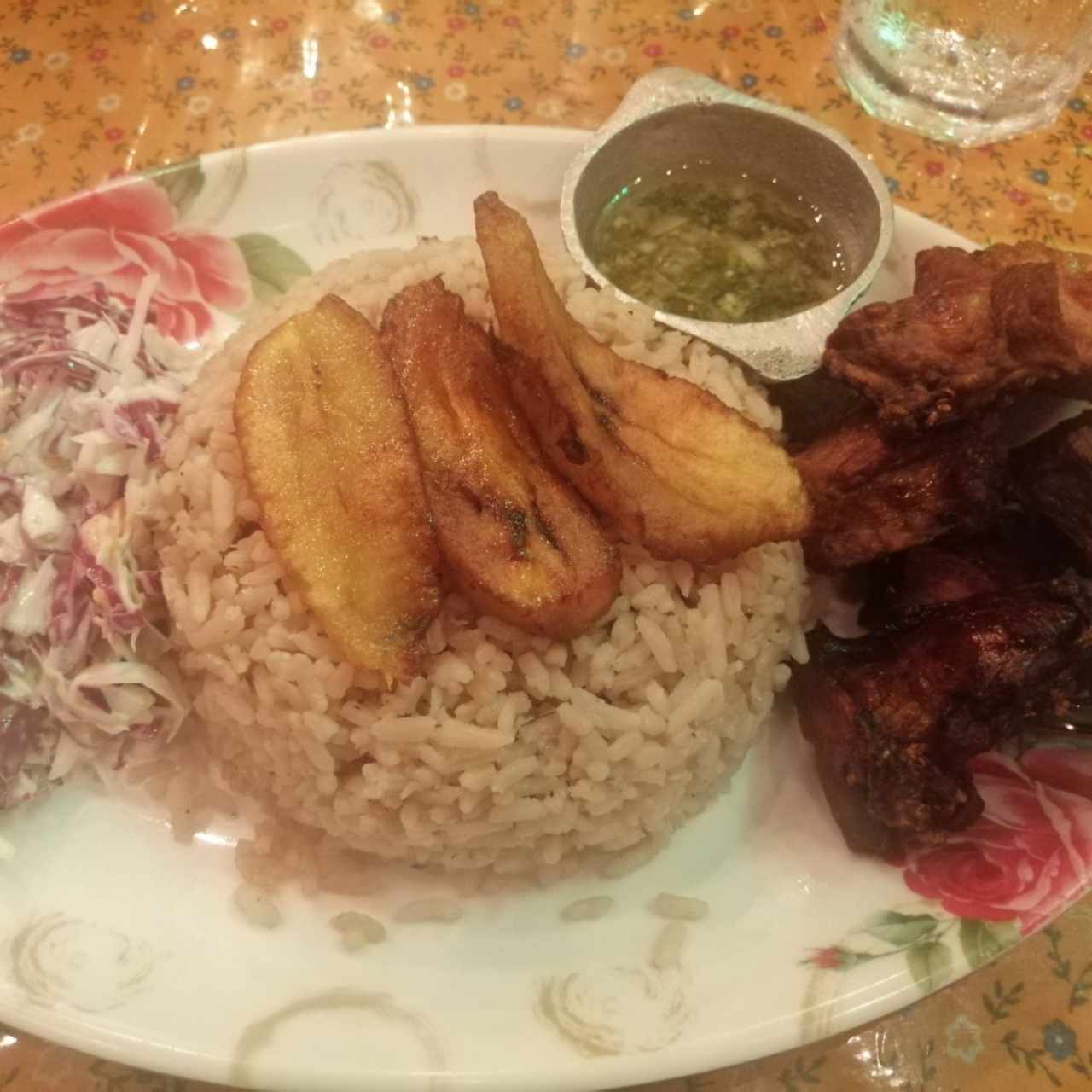 Lechona ahumada, arroz con coco, ensalada de repollo, tajadas de Plátano maduro y salsa chimichurri