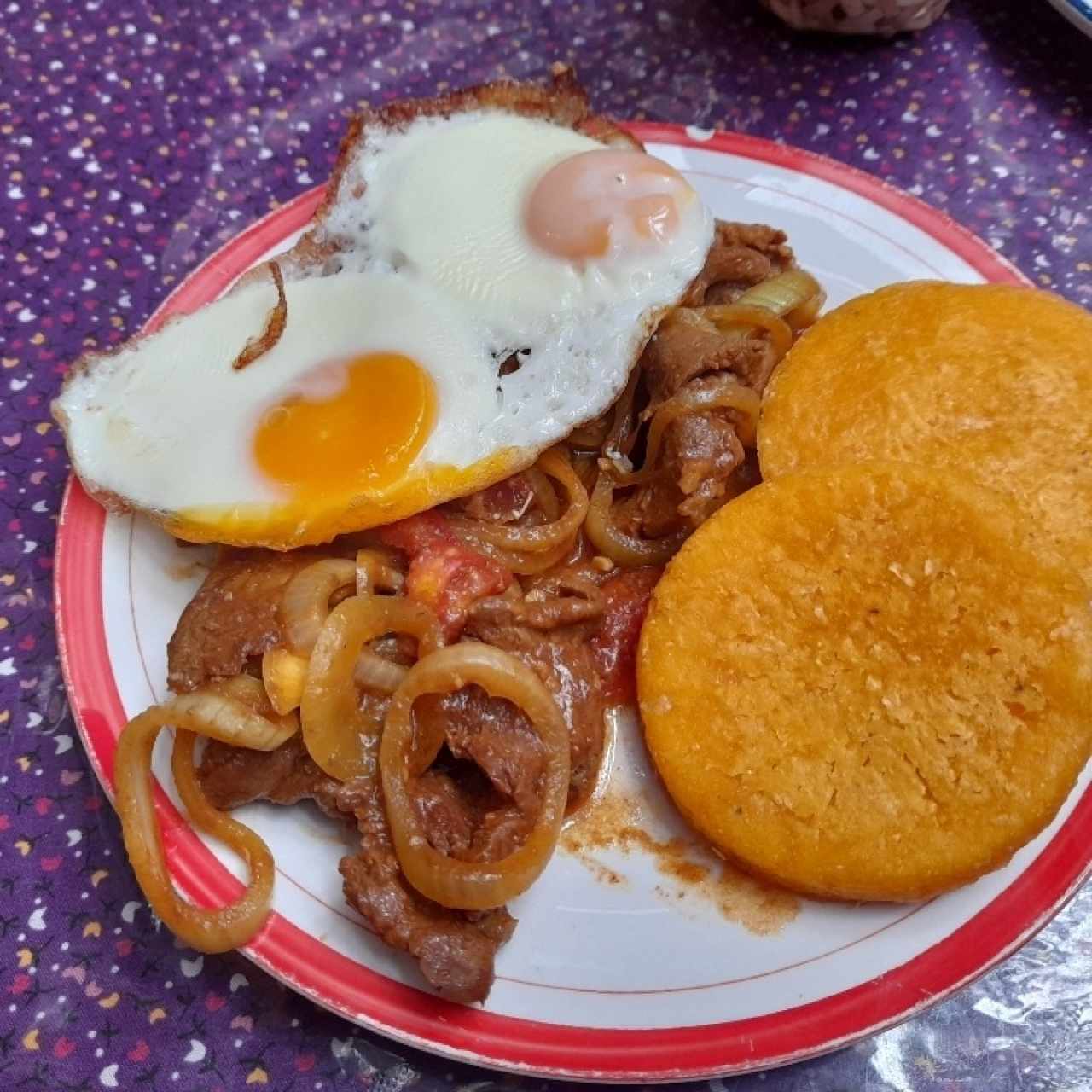 Bistec de carne de res encebollado con tortilla la caballo. 