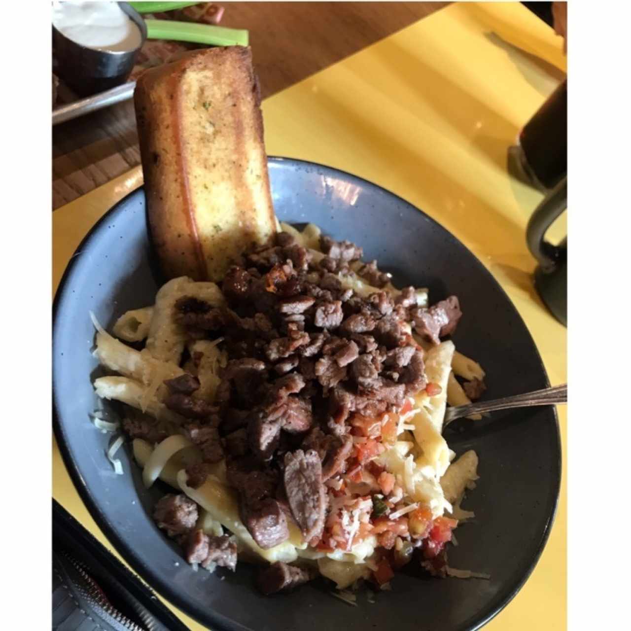 Penne en salsa blanca con pedazos de tomate y carne 