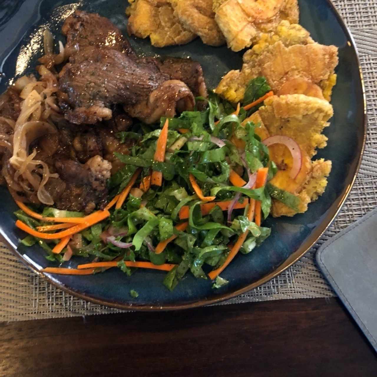 Bistec encebollado, patacones y ensalada verde