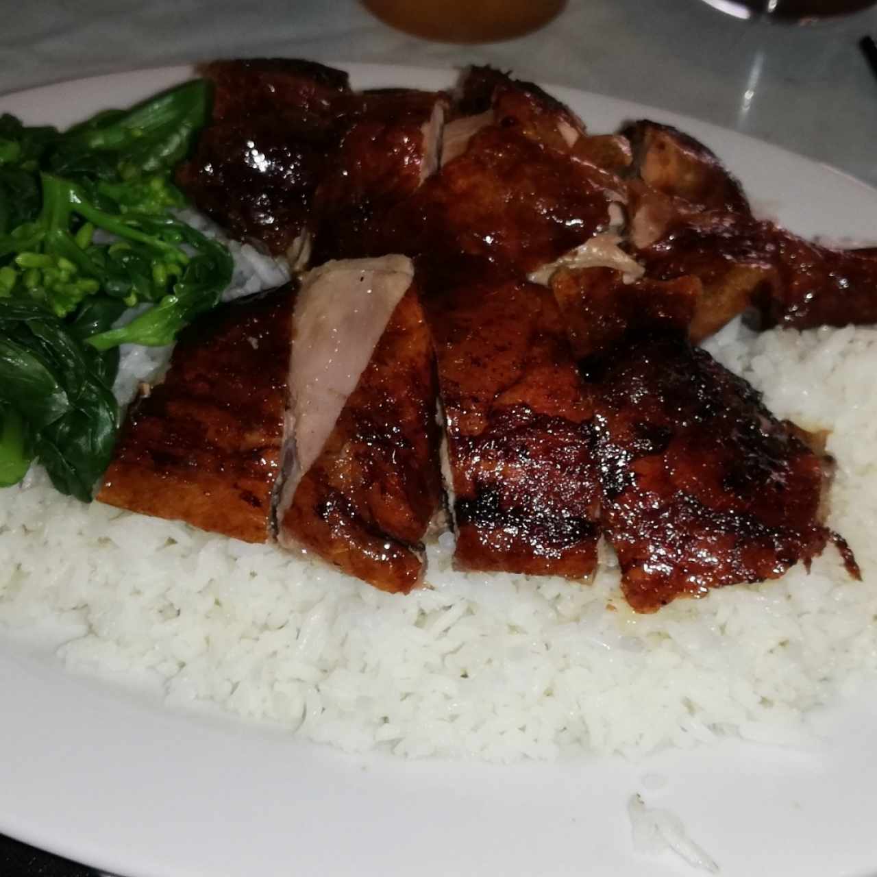 Pato asado con arroz y hojas de mostaza