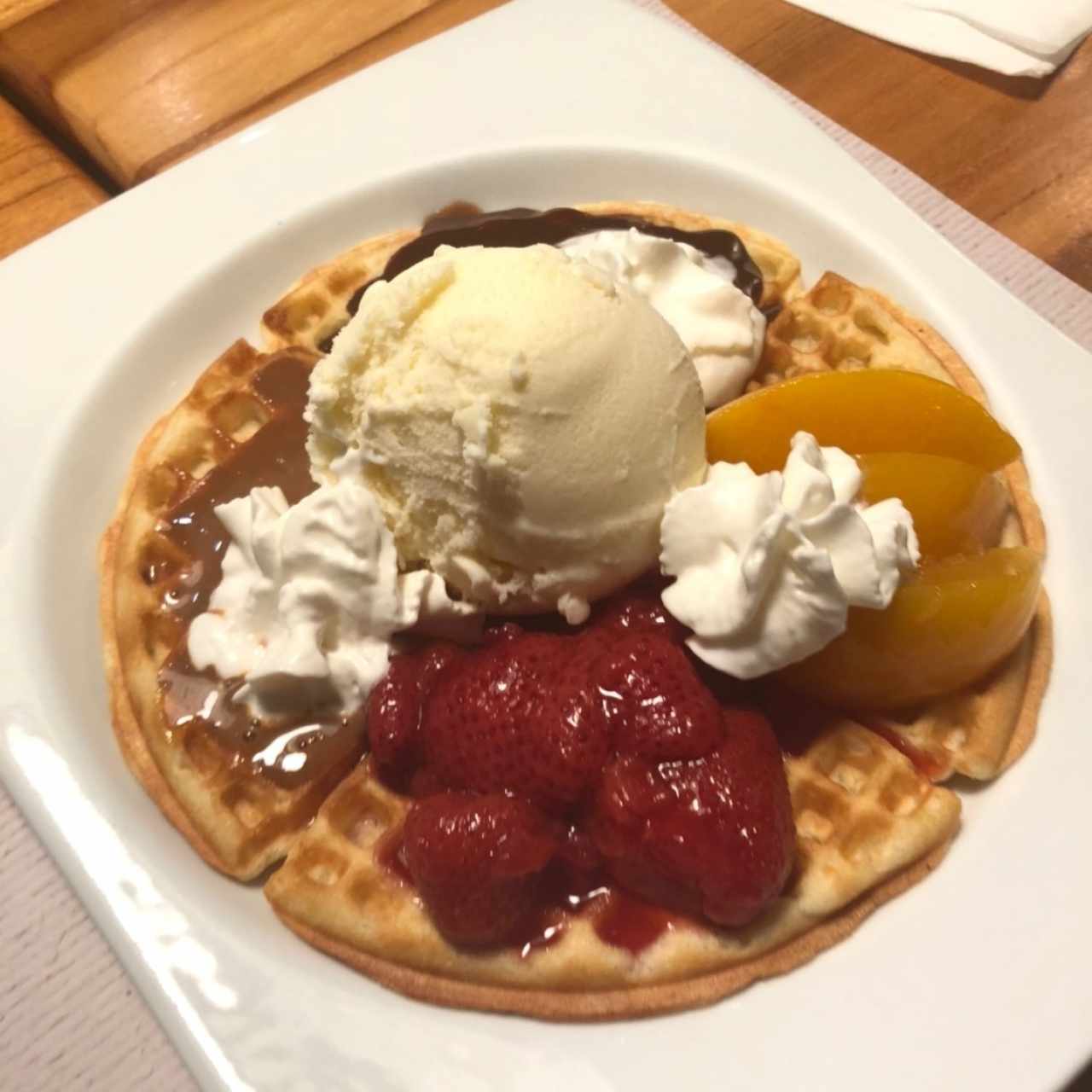 Waffle de fresa, dulce de leche, melocotón y chocolate