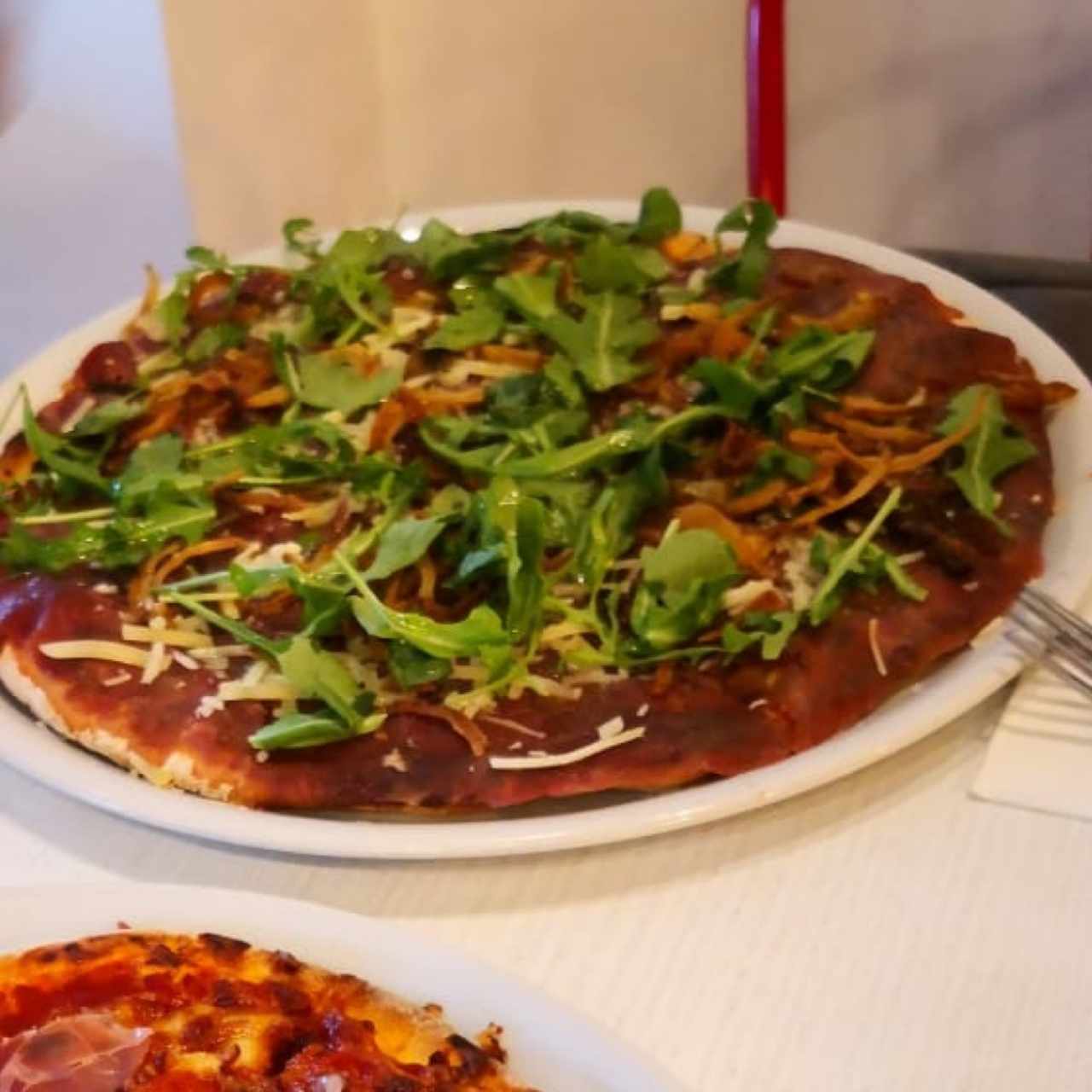 pizza bañada con aceite de trufas y arugula