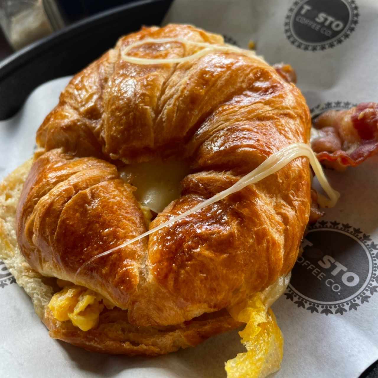 Croissant de huevos , queso suizo y tocino 