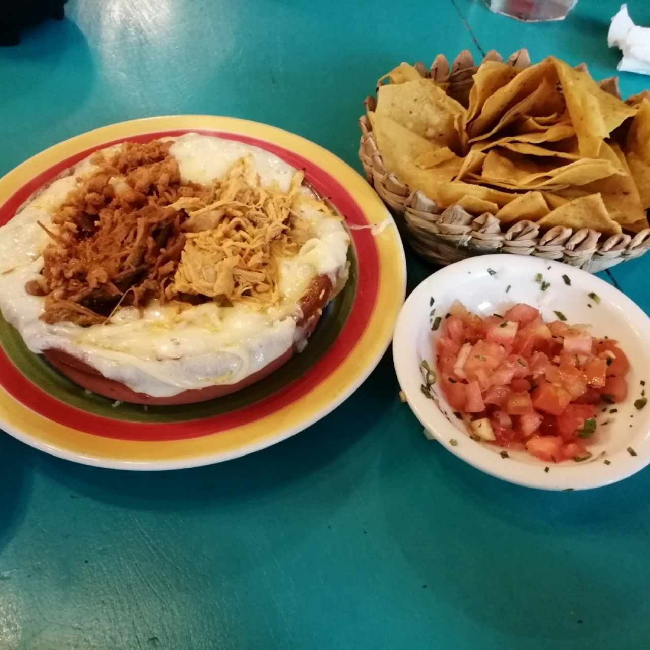 Entrada de queso fundido con carnitas, totopos y pico de gallo 