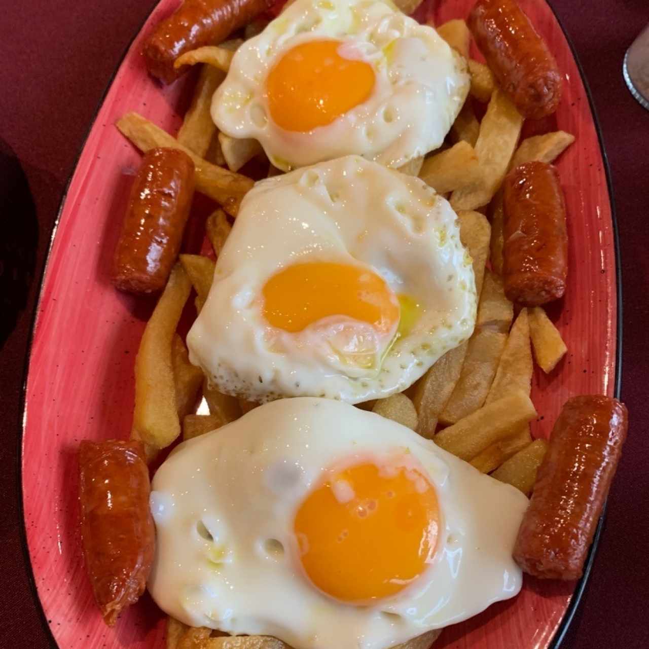 Huevos rotos con chistorra en cama de patatas