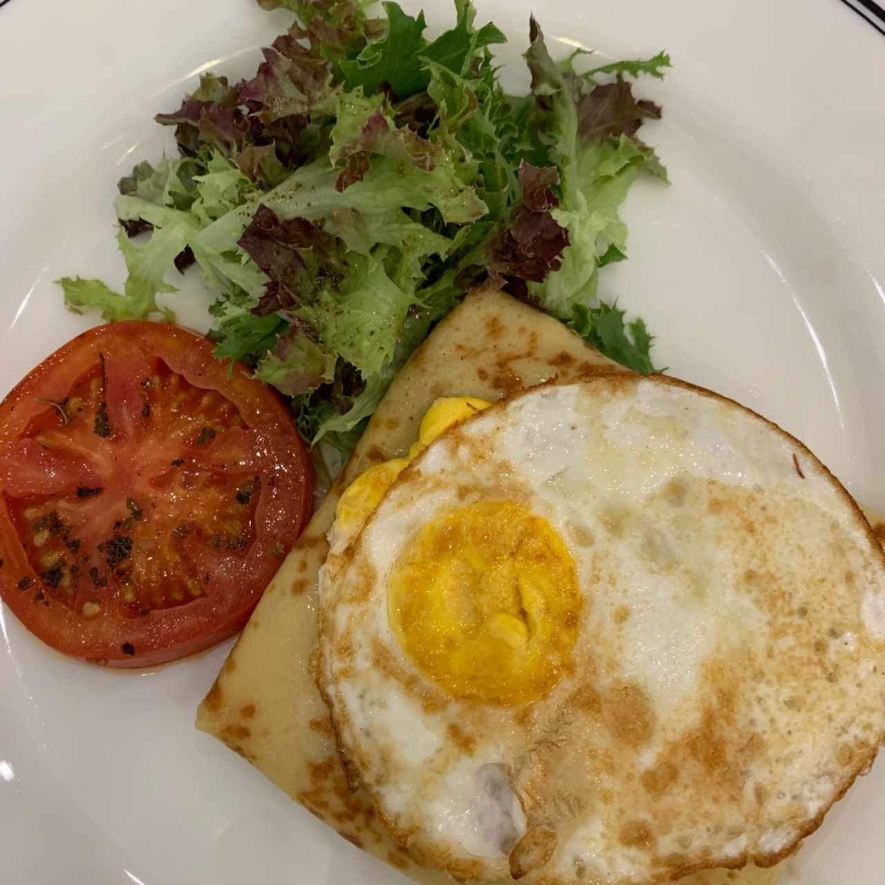 Crêpe relleno de jamón y queso cheddar con huevo frito encima. 