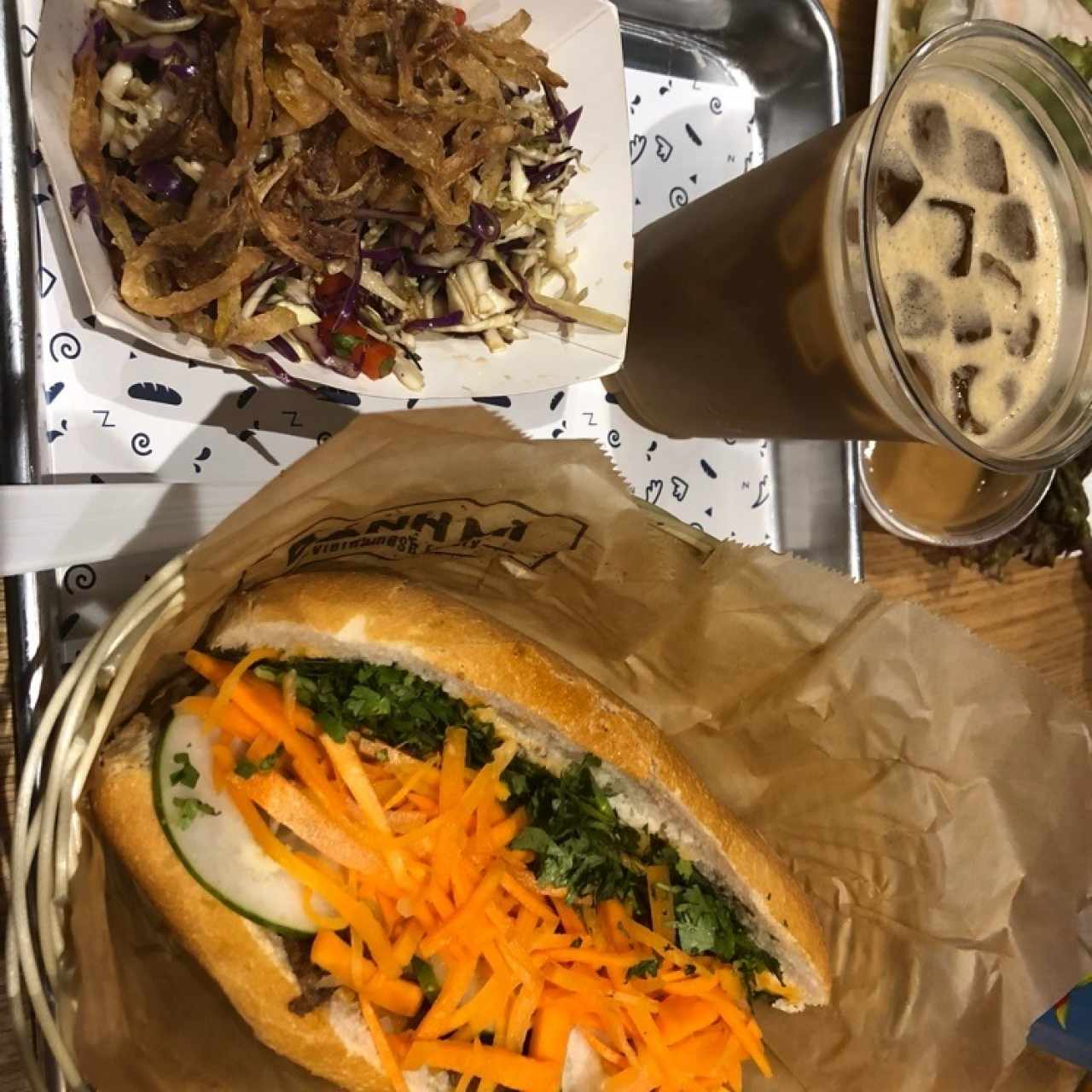 Five spice pulled pork Banh Mi con ensalada y Iced Ca Phe