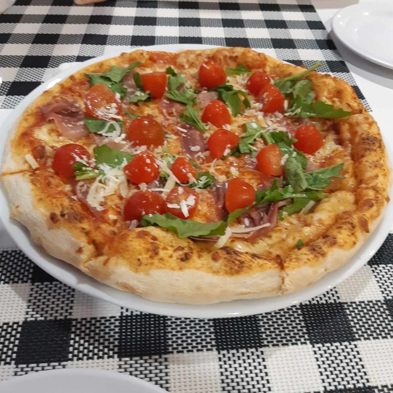 pizza de procciuto y tomates cherry