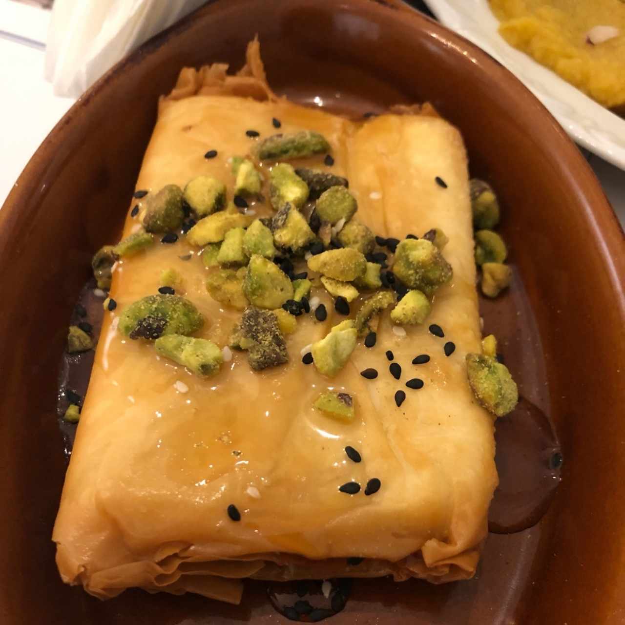 queso feta envuelto en filos con miel de abeja y pistachos