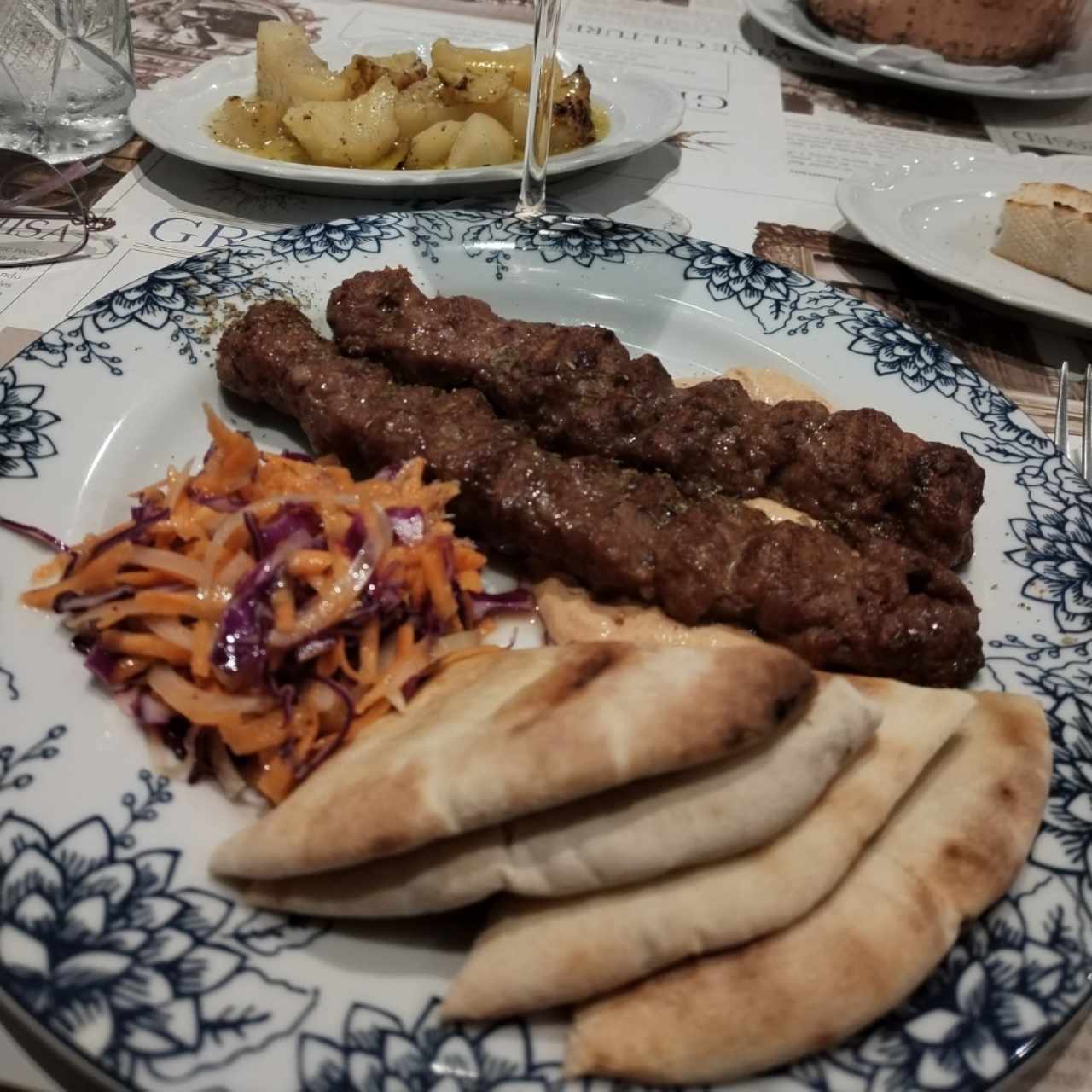 Pinchos de cordero con pan pita y ensalada de la casa. 