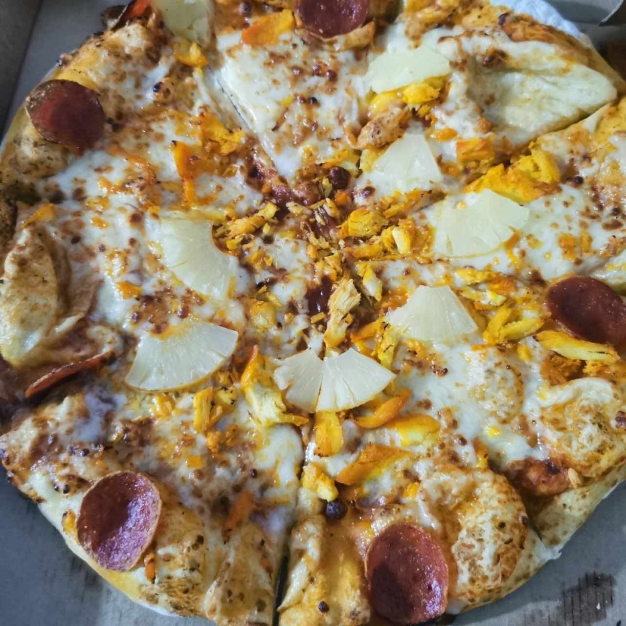 Pizza de pollo, peperoni, piña