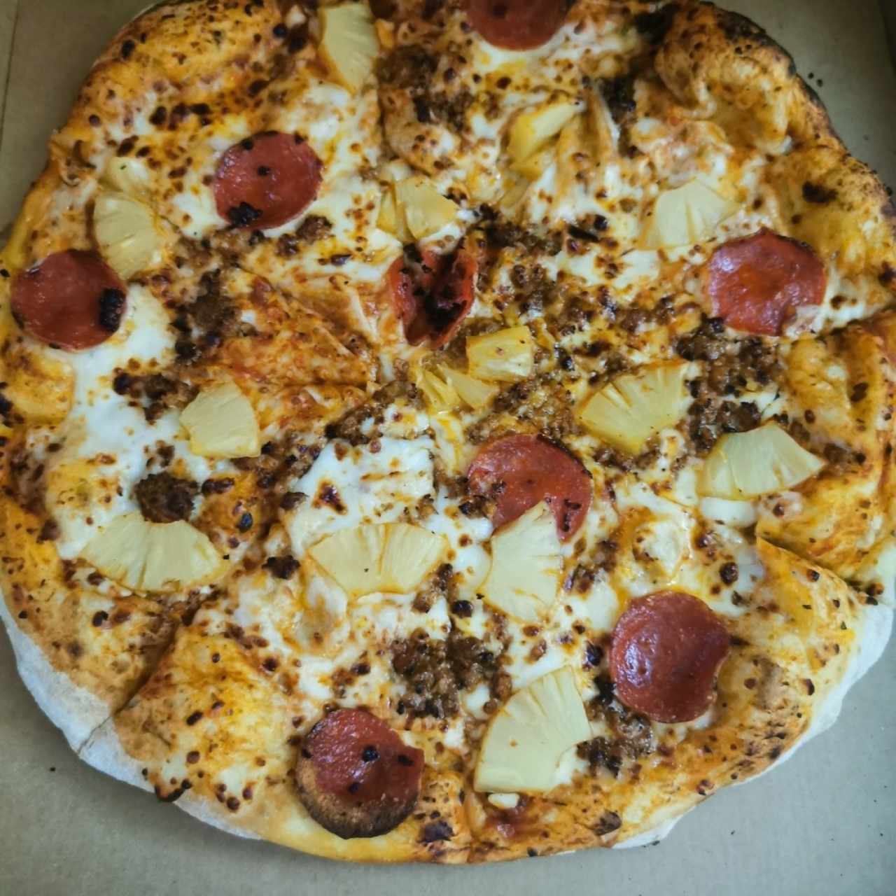 Pizza de peperoni, piña y carne molida